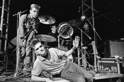 Da esquerda para a direita: Andy Rourke, Mike Joyce e Johnny Marr, com Morrissey deitado à frente. Foto: Mirrorpix/ Reprodução